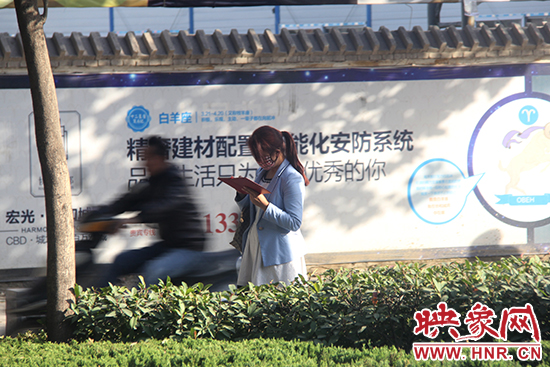 一名女士看著手機(jī)走路 一名女士看著手機(jī)走路