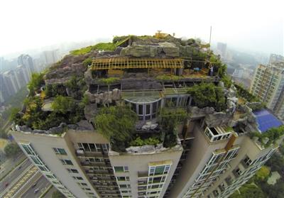 　　昨日，身穿橘黃色馬甲的工作人員在人濟(jì)山莊樓頂拆除違章建筑。新京報(bào)記者 吳江 攝