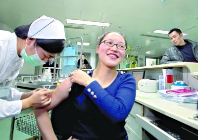 昨日，向雪敏在同濟醫(yī)院血液科病房打動員劑，丈夫陳武右在身后注視著妻子 記者傅克強