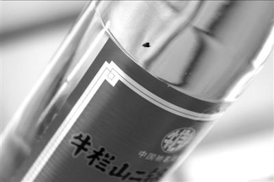 圖中畫圈處為瓶中的黑色異物。京華時報記者 譚青 攝