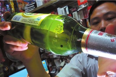 這瓶未開封的燕京啤酒內(nèi)有一顆黑色懸浮物。京華時(shí)報(bào)記者 徐曉帆 攝