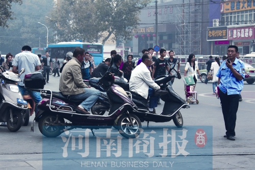 　火車站廣場北側(cè)，幾輛摩的正在等客