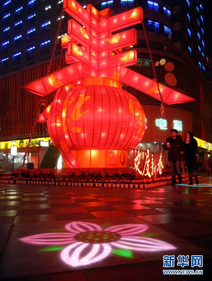 　1月30日晚，市民從蘇州市石路銀河廣場上大型“春”字彩燈景觀旁經(jīng)過。