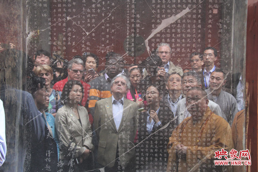 在一塊石碑前，少林寺方丈正在講解