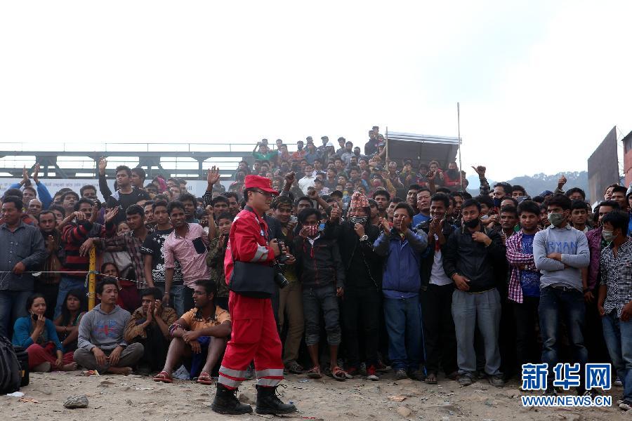 圍觀的尼泊爾民眾在中國國際救援隊成功搜救出幸存者后向搜救隊員歡呼致意。