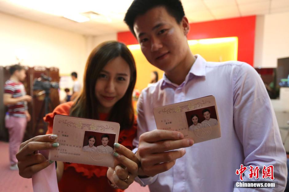 5月20日,河南鄭州,一對準新人領(lǐng)完結(jié)婚證后秀自拍。