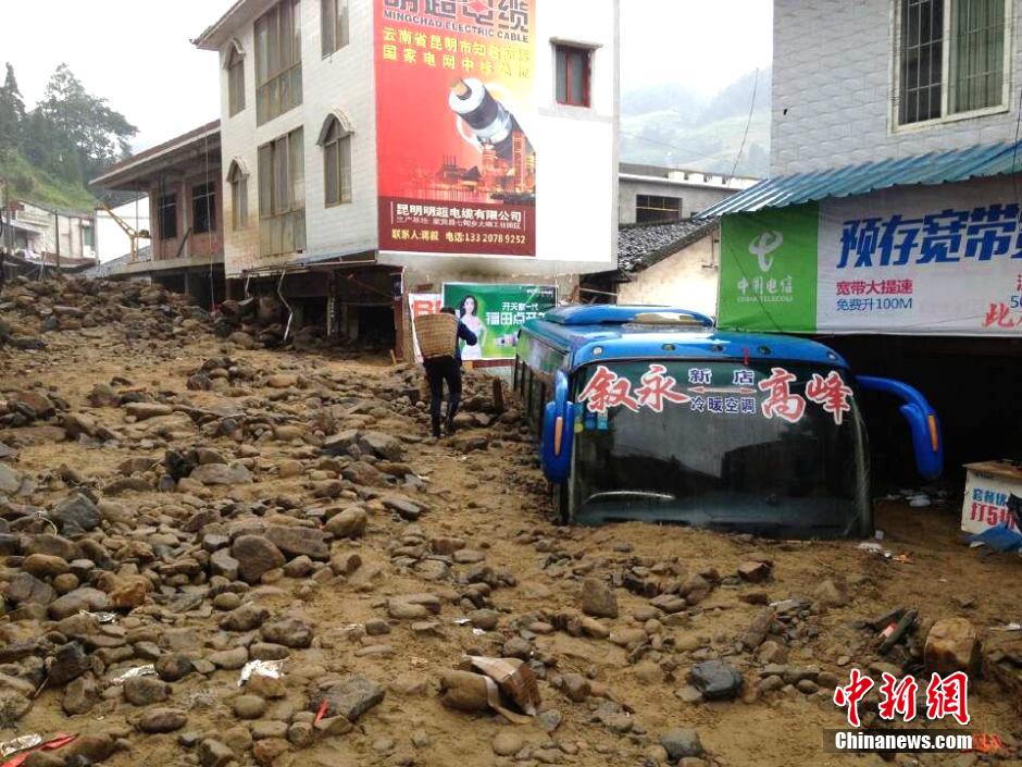 圖為山洪泥石流導沖進鄉(xiāng)鎮(zhèn)街道，導致客車被埋。