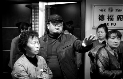 昨日，在河北香河天下第一城，相關(guān)負責(zé)人（左二）走出會議室與參加演出的老人們溝通。