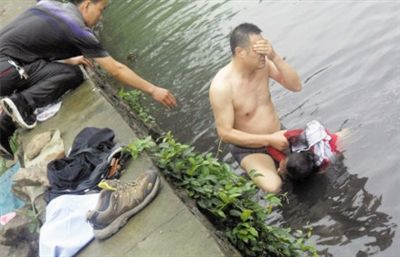 網(wǎng)友貼出民警張光聰一出河水就睜不開眼，用手抹去臉上臟水的照片。