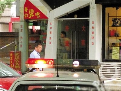 闖入面館的持刀男子與趕來的民警隔著玻璃門對(duì)峙，后店內(nèi)一名女童被其劫持。網(wǎng)友供圖