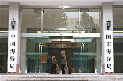 昨日，中國(guó)海警局掛牌成立。原國(guó)家海洋局和中國(guó)海監(jiān)總隊(duì)的牌匾被摘下，國(guó)家海洋局和中國(guó)海警局的新牌匾換上。黃冉 攝