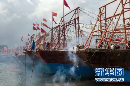 2013年8月1日 南海開漁日 臨高迎新港 8月1日，海南省臨高縣漁民在船上鳴放鞭炮慶祝武蓮港開港。