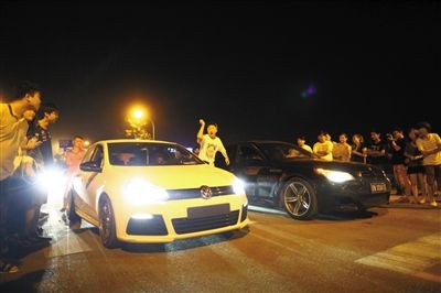8月24日晚，東壩中街飆車現(xiàn)場(chǎng)，兩輛車并排等待出發(fā)指令，旁邊許多愛好者前來觀看比賽。新京報(bào)記者
