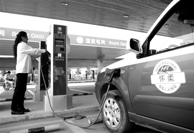 9月11日，懷柔區(qū)，電動(dòng)出租車司機(jī)正在為車輛充電。