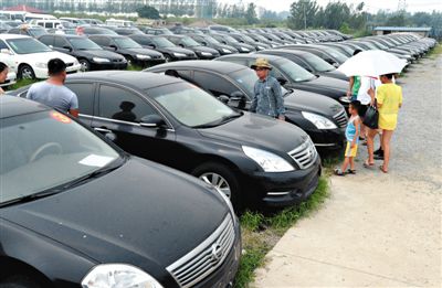 昨日，市民在山東棗莊一家拍賣公司場(chǎng)地上查看待拍賣公車。當(dāng)日，棗莊市103輛公車公開拍賣。新華社記者
