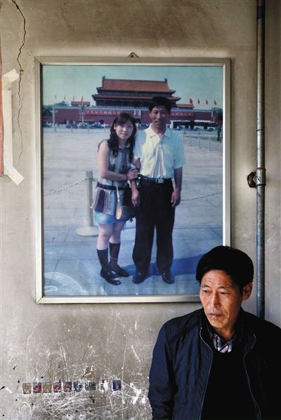 11月14日，承德市平泉縣，潘小梅父母的家，潘小梅父親靠在墻上，身后掛著數(shù)年前他和潘小梅在北京的合影照片。新京報記者
