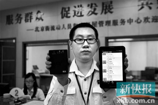 　越秀區(qū)北京街出租屋外來暫住人員管理服務(wù)中心的工作人員展示到出租屋登記來穗人員信息的儀器。