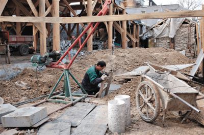 東城區(qū)北鑼鼓巷與小經廠胡同之間一處四合院內，工人進入已經挖好的地下室內施工。