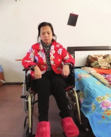 陳慶霞坐在輪椅上。她現(xiàn)在下身癱瘓，疾病纏身，生活不能自理。