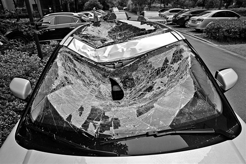 越野車車蓋以及前擋風(fēng)玻璃被砸得凹陷進去。見習(xí)記者姚卡/攝