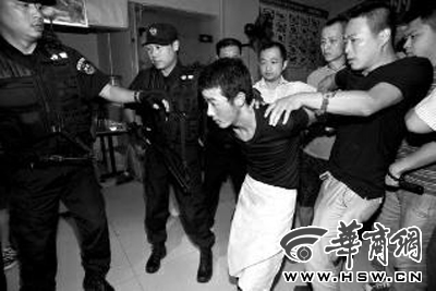 犯罪嫌疑人韓牙某圍著圍裙在廚房內拉面，被民警抓獲 本報記者 鄧小衛(wèi) 攝