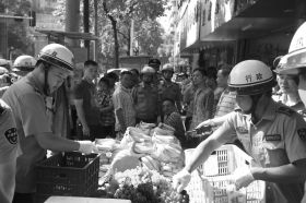 7月11日，瀏陽市北正中路，執(zhí)法人員暫扣張海的水果。這是瀏陽市城管局拍攝的執(zhí)法現(xiàn)場圖。
