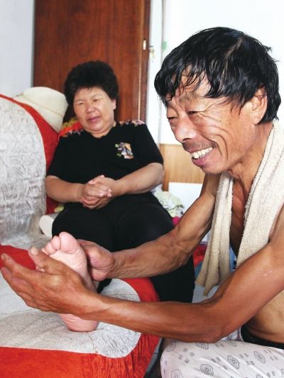 慈成富為老伴按摩。