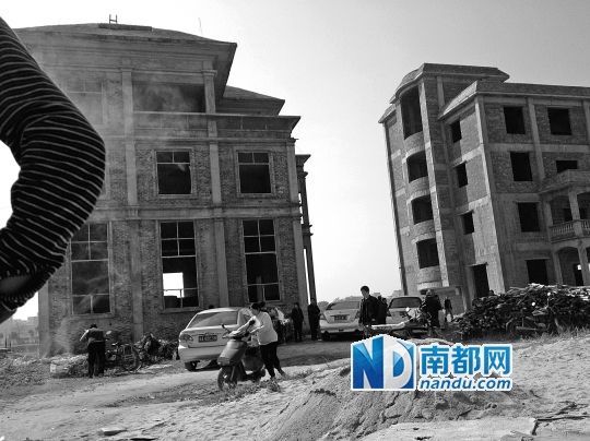 兩棟被舉報(bào)的違建樓下昨日一度聚集了超過(guò)百人，城管離開后逐漸散去。南都記者張志韜實(shí)習(xí)生宋超攝