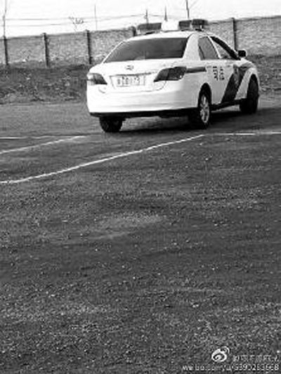 一輛車牌號 為“ 陜DD173”的制式警車停在一個劃著白線的場地上，車身標有“司法”字樣