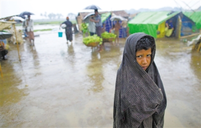 5月14日，緬甸若開邦實(shí)兌難民營，羅興亞族難民在雨中行走。熱帶風(fēng)暴“馬哈森”即將登陸緬甸，這里的難民開始乘船撤離。