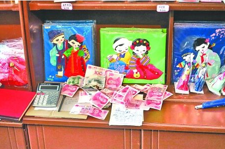 　　2012年6月21日，在朝鮮羅先特別市的一家商店里，柜臺(tái)上散落著一些人民幣。在朝鮮，人民幣比本國(guó)