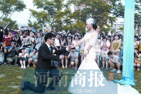 在學(xué)校操場(chǎng)的草坪上，兩名畢業(yè)生舉行婚禮，有同學(xué)感動(dòng)地抹起眼淚