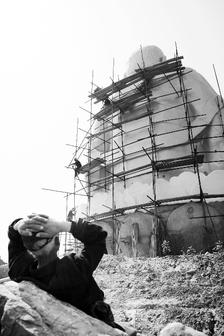 今年4月26日，工作人員將帆布蓋在“佛像”頭像上
