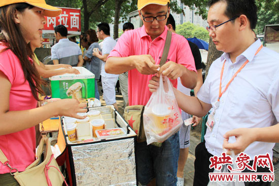 圖為徐貴雨和一名勤工助學(xué)的學(xué)生在街頭義賣快餐。