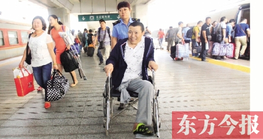 李剛手術(shù)后歸來，在車站工作人員幫助下走出鄭州火車站站臺  東方今報首席記者 張曉冬 攝