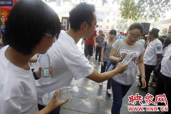 志愿者為剛剛考試完的考生送上1瓶冰凍的冰露·純悅，消暑解渴為考生加油