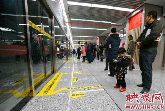 小朋友在等候區(qū)內(nèi)等待地鐵。