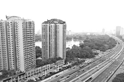 昨日，人濟山莊小區(qū)，與其他樓相比，B棟樓頂層天臺上違規(guī)建造了一棟兩層小樓，假山大樹俱全。新京報記者