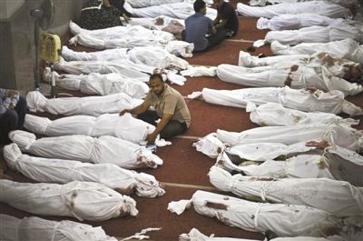 8月15日，在埃及首都開羅的一個清真寺，人們在成排的遺體旁哀悼。