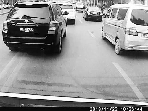 這輛黑色車輛不避讓執(zhí)行緊急任務(wù)的救護(hù)車，并壓著雙黃線變更車道。唐韜/圖
