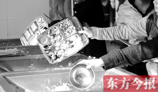 11月27日，河南中醫(yī)學(xué)院餐廳，一名同學(xué)將餐盤(pán)內(nèi)沒(méi)吃完的食物倒入餐具回收車(chē)內(nèi)