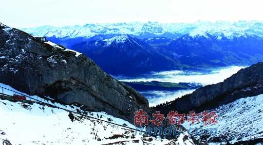  齒軌火車(chē)在皮拉圖斯山上穿行，如同紅色的龍?jiān)谏街杏芜? complete=