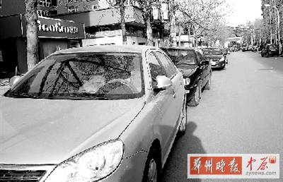 友愛路，路邊停了一排車，本來(lái)不寬的路就變得更窄了。