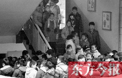 　某小學(xué)的學(xué)生走下樓梯放學(xué)。