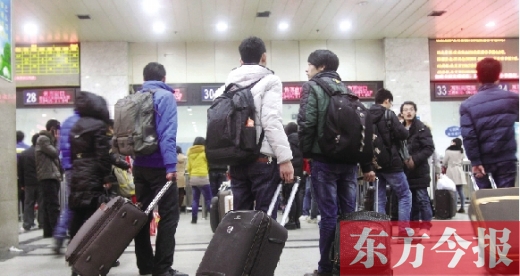 鄭州火車(chē)站東廣場(chǎng)售票大廳，幾名學(xué)生在售票窗口前躊躇