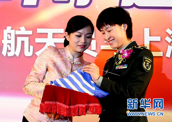 11月1日，航天員劉洋（右）在為“愛心”毛衣編織最后的收尾針。