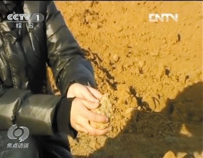 麻剛沙系麻剛石粉碎而成。記者找到一塊麻剛石，一捏就碎成粉末，硬度非常差。央視截圖