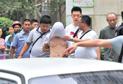 昨日，成都警方抓捕時與毒犯發(fā)生槍戰(zhàn)。一名男犯罪嫌疑人被警方押出。