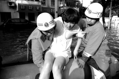 10月10日，前來余姚支援的杭州消防支隊武警官兵在南西路幫助轉(zhuǎn)移被困群眾。新華社發(fā)