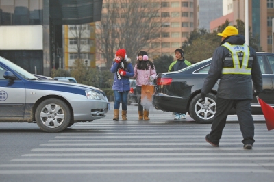 過(guò)斑馬線，行人左顧右盼，汽車(chē)寸土必爭(zhēng)。
